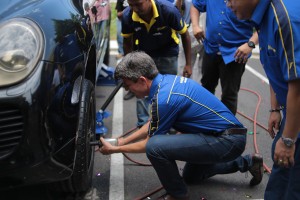 Ben Hoge, Managing Director for Goodyear Malaysia Berhad, officiating the launch of SDGR Goodyear Autocare by securing a tire onto a vehicle.